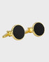 Gold cufflinks with black round stones on a light gray background