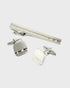 Silver cufflinks and tie clip set on a white background