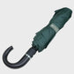 Green umbrella with black handle on a light gray background