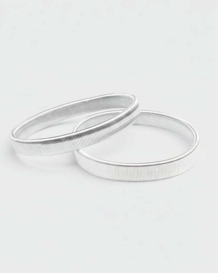 Silver armbands on a light gray background