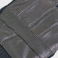Close-up of a black leather glove with visible stitching on a light gray background