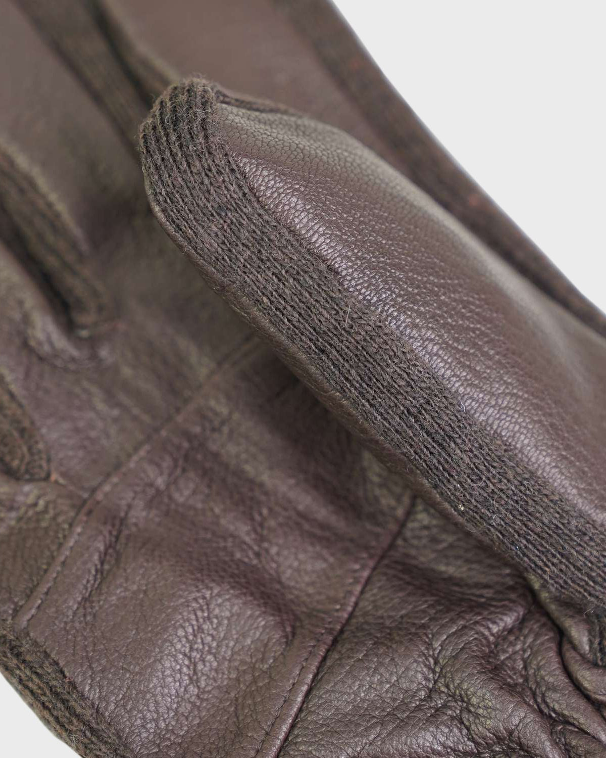 Close-up of brown leather gloves with a focus on the wrist area.