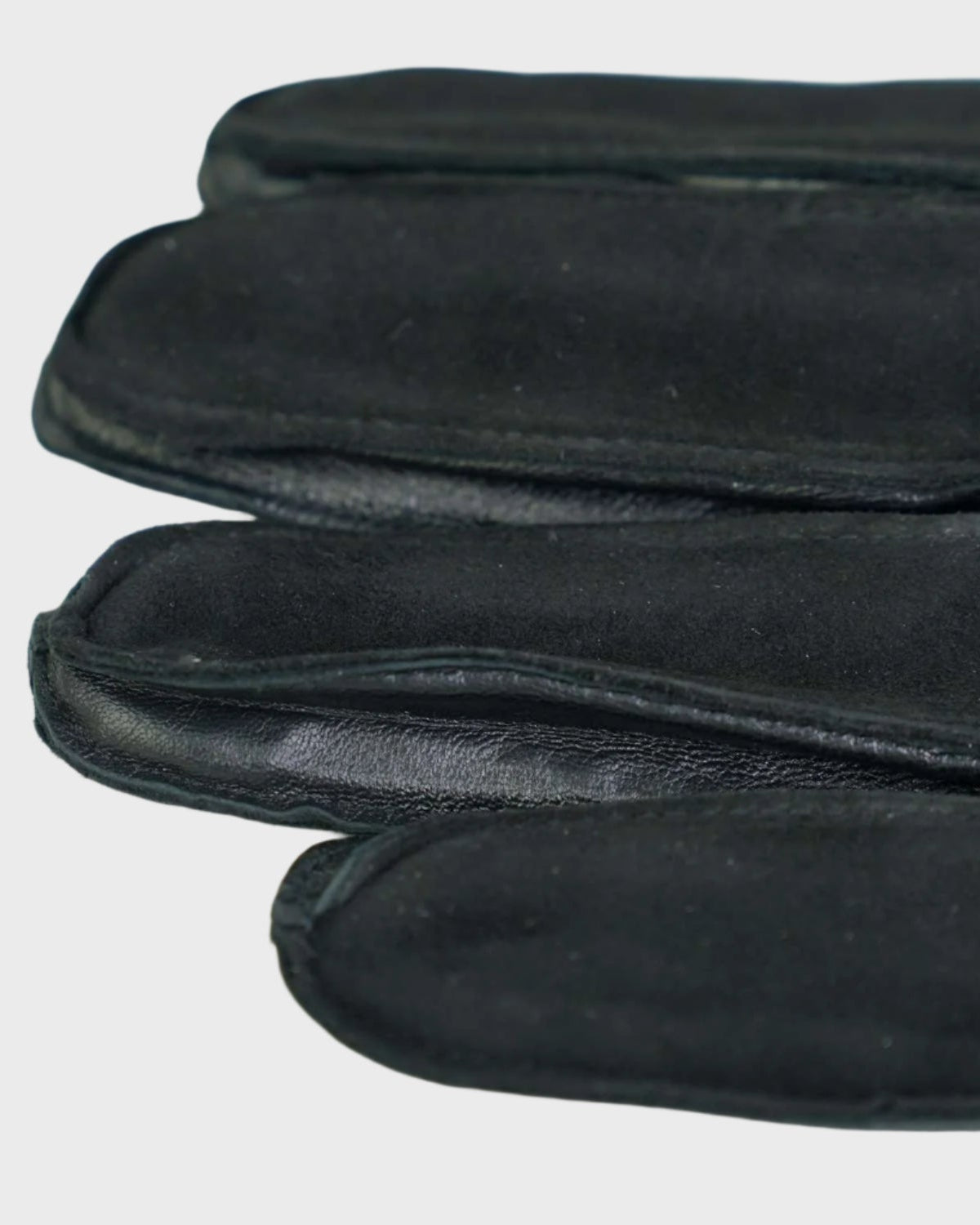 Black leather gloves on a light gray background