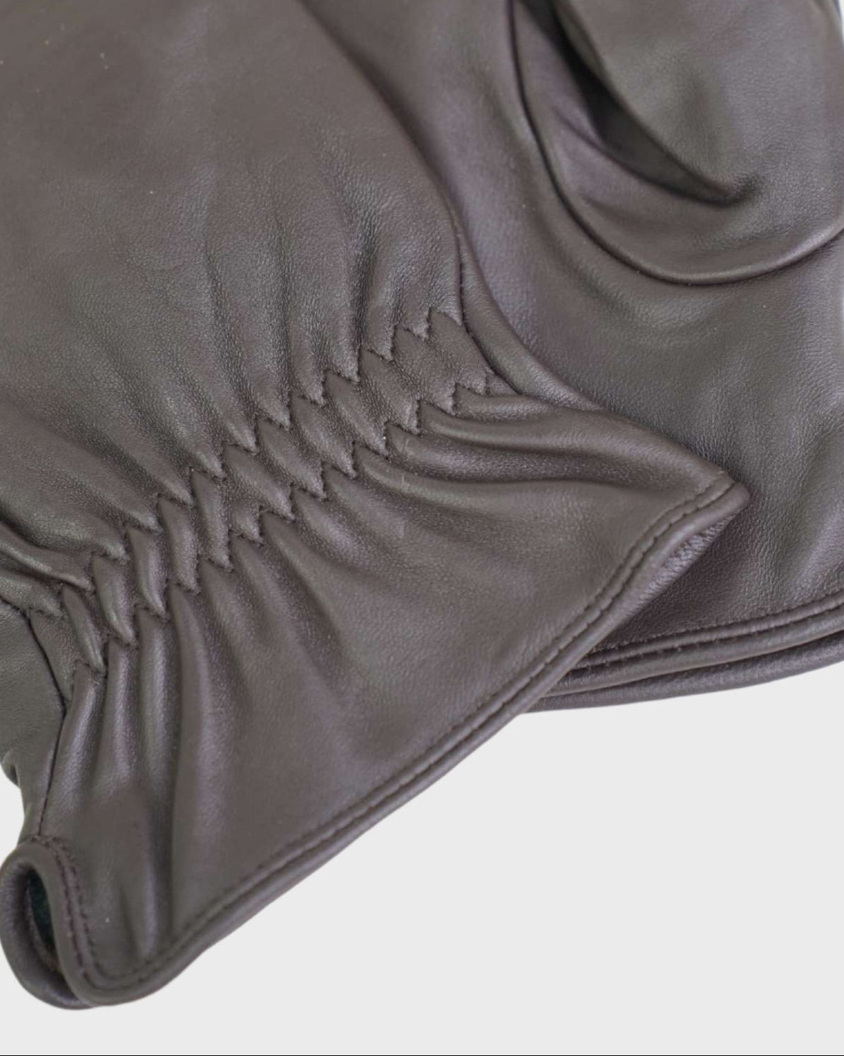 close up of leather gloves on a light gray background