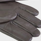 Pair of brown leather gloves on a light gray background