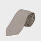 Folded beige tie on a light gray background