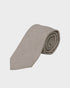 Folded beige tie on a light gray background