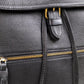 Close-up of a black leather backpack with gold zippers