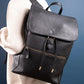 Person wearing a black leather backpack against a blue background
