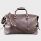 Brown leather holdall with shoulder strap on a light gray background