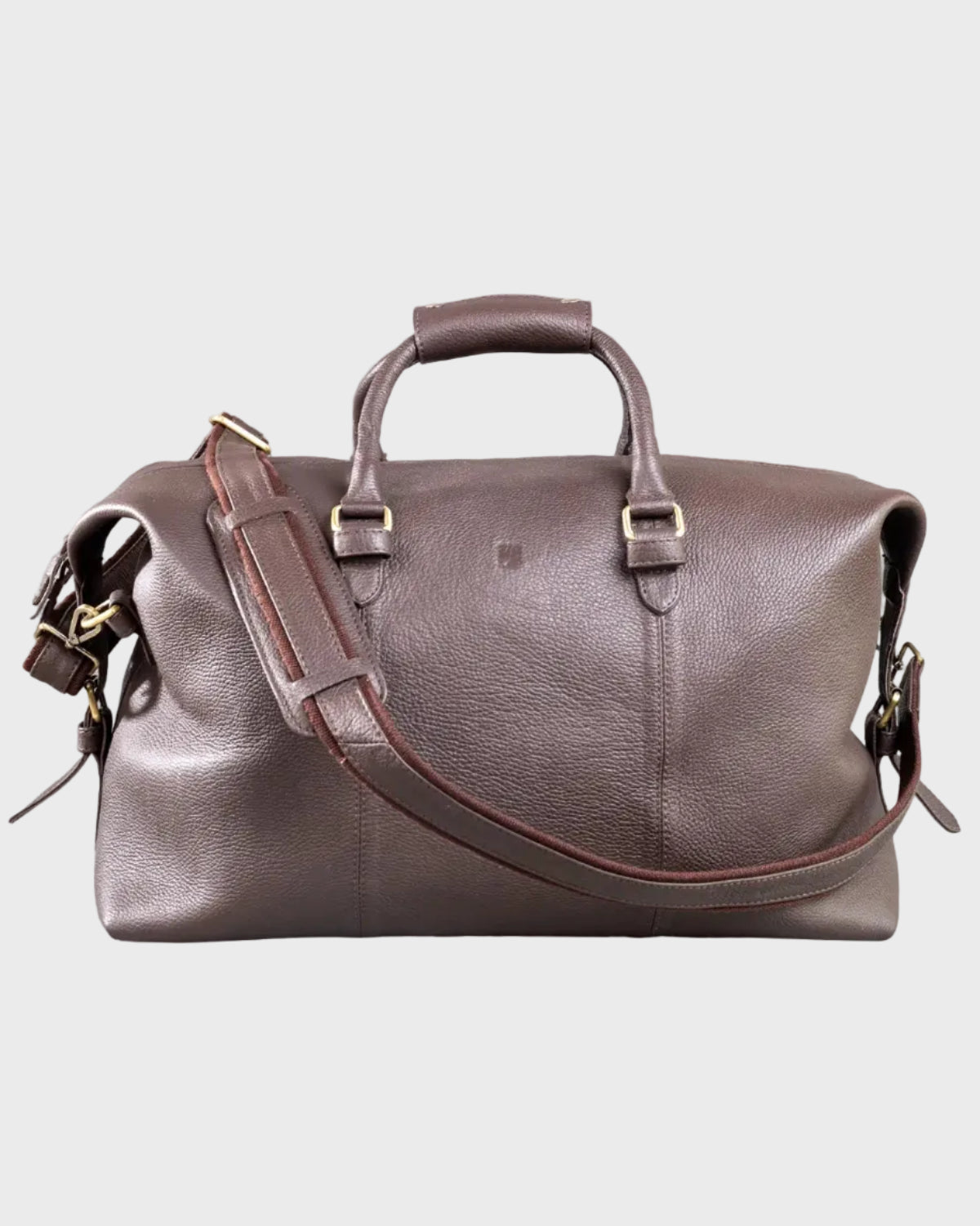 Brown leather holdall with shoulder strap on a light gray background