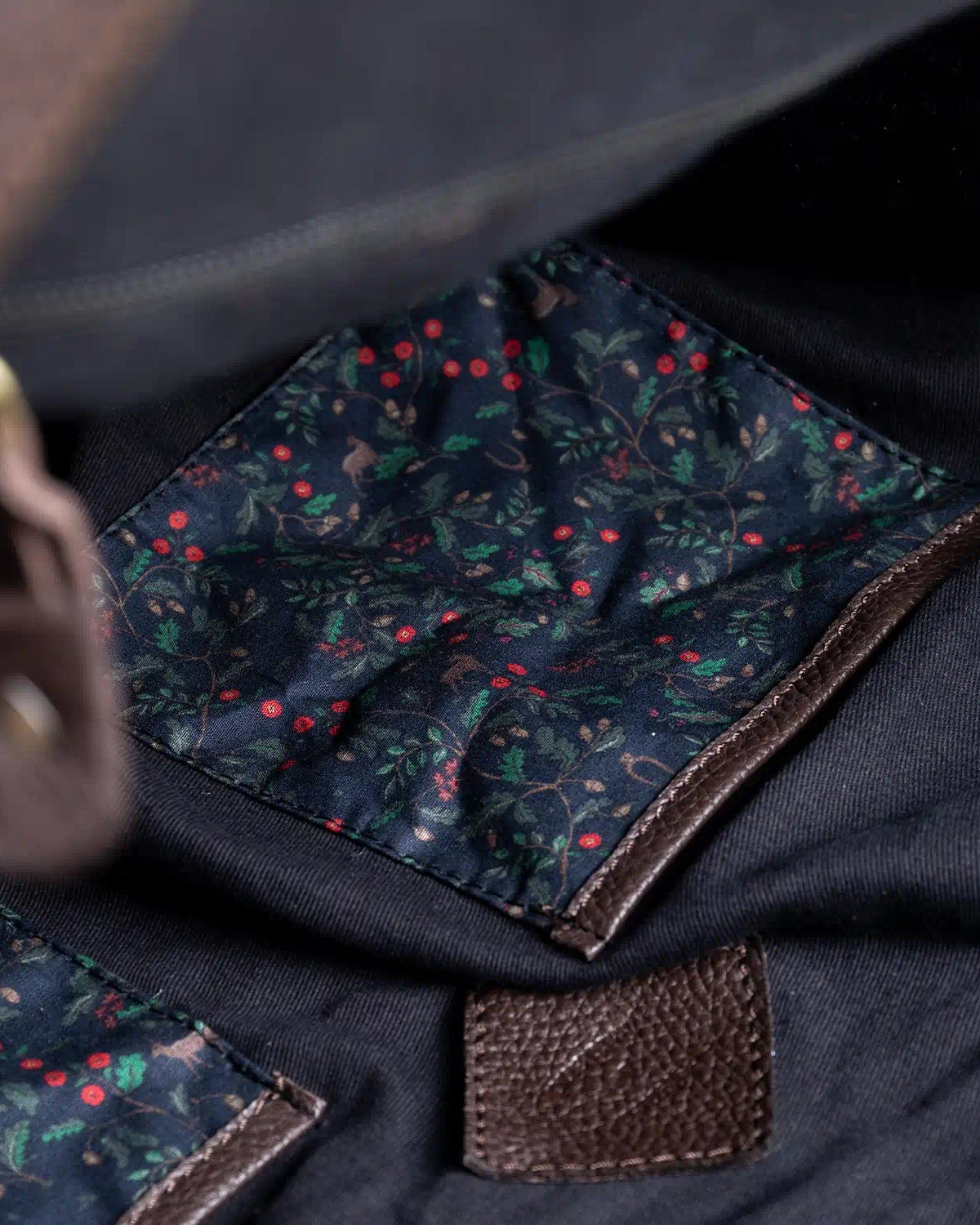 Close-up of a navy lining with heritage pattern and brown stitching