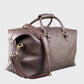 Brown leather holdall with gold hardware on a light gray background