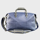 Navy leather holdall with gray straps on a light gray background
