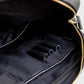 Close-up of a black bag with a zipper on a light gray background