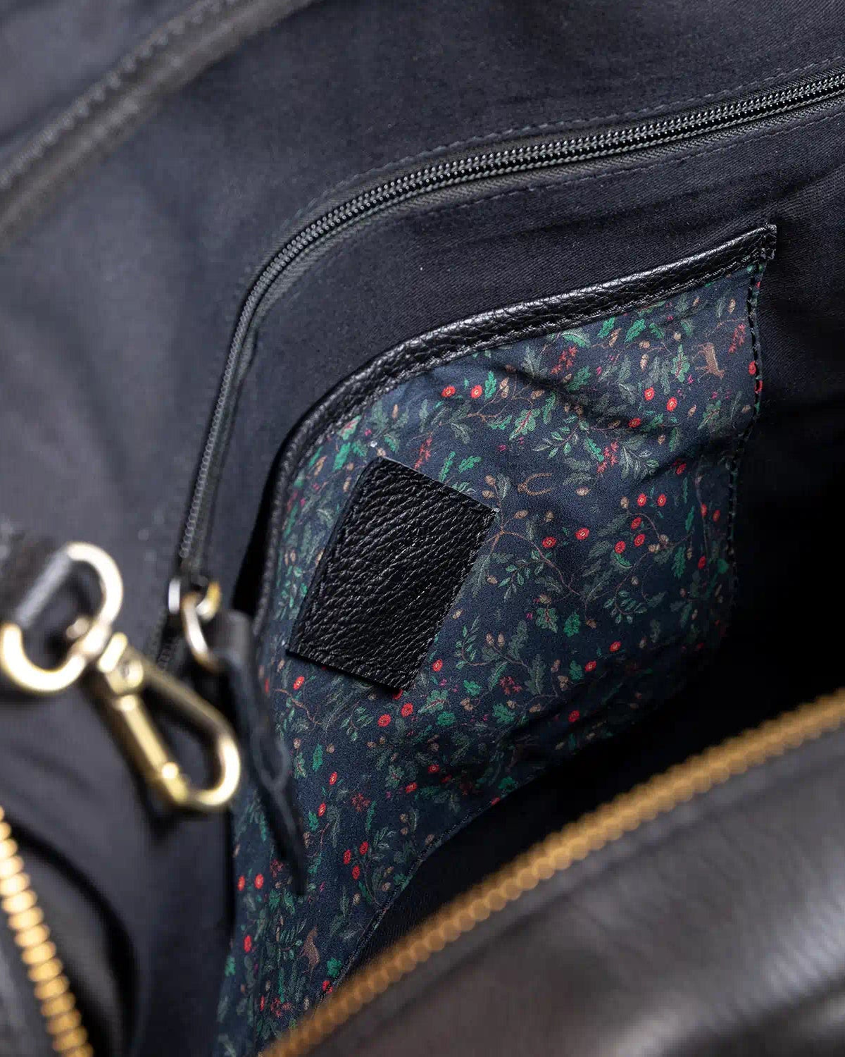 Close-up of a black bag with a floral patterned pocket.