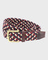 Woven belt with a brass buckle on a light gray background