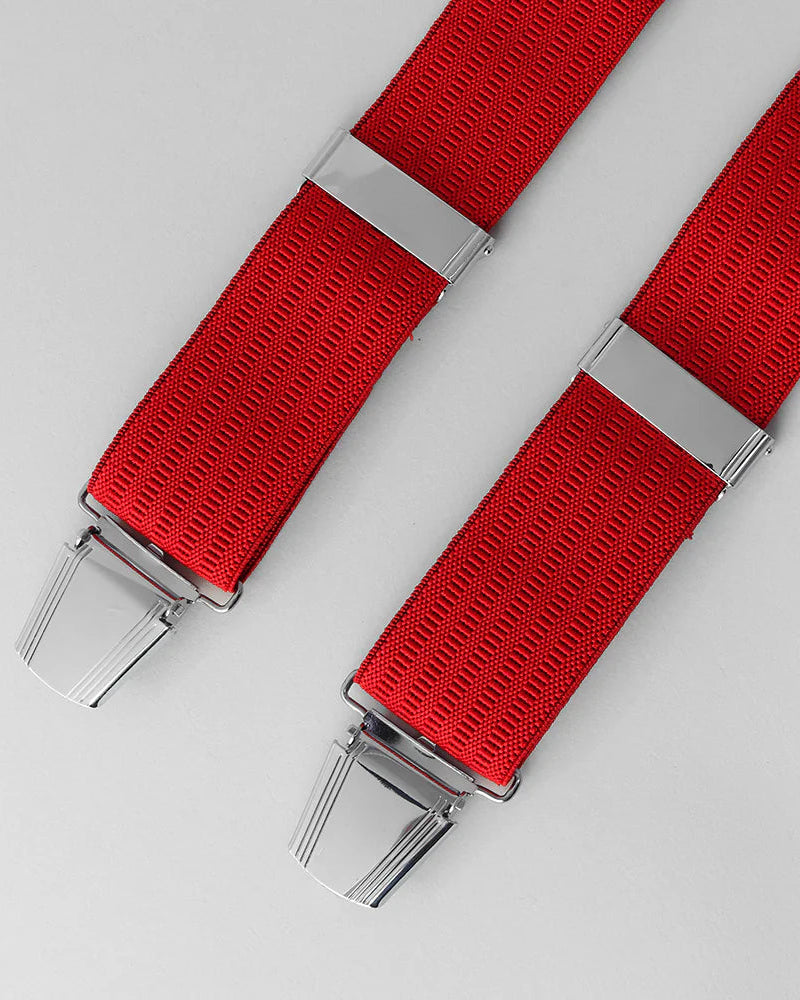 Red braces with silver clips on a light gray background