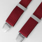Red braces with silver clips on a light gray background
