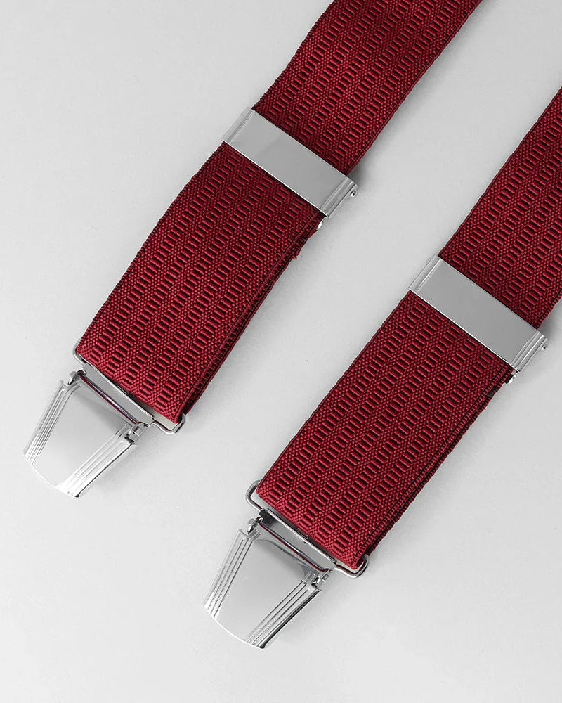 Red braces with silver clips on a light gray background