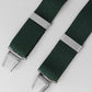 Green braces with silver clips on a light gray background