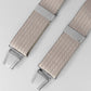 Beige braces with silver clips on a light gray background