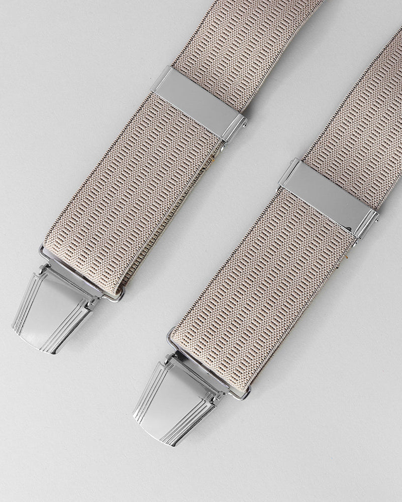 Beige braces with silver clips on a light gray background