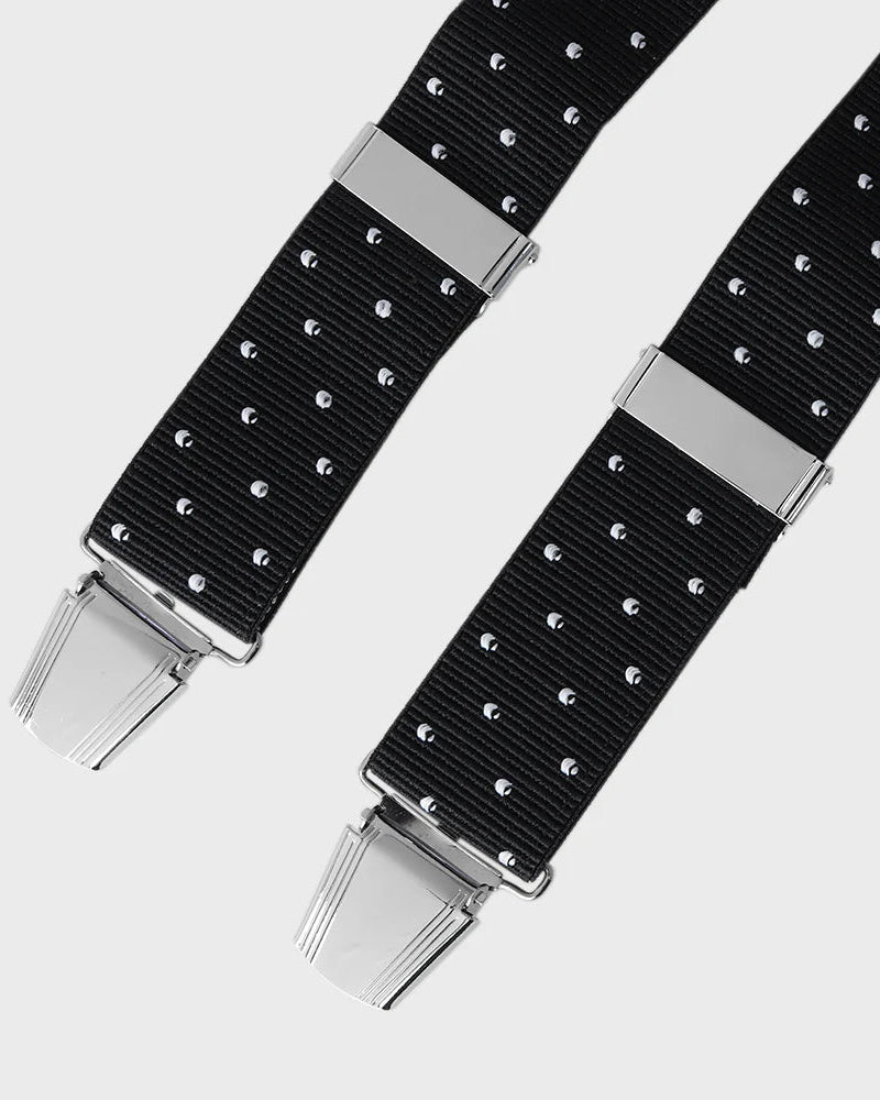 Black polka dot braces with silver clasp on a light gray background