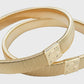 Gilt armbands on a light gray background