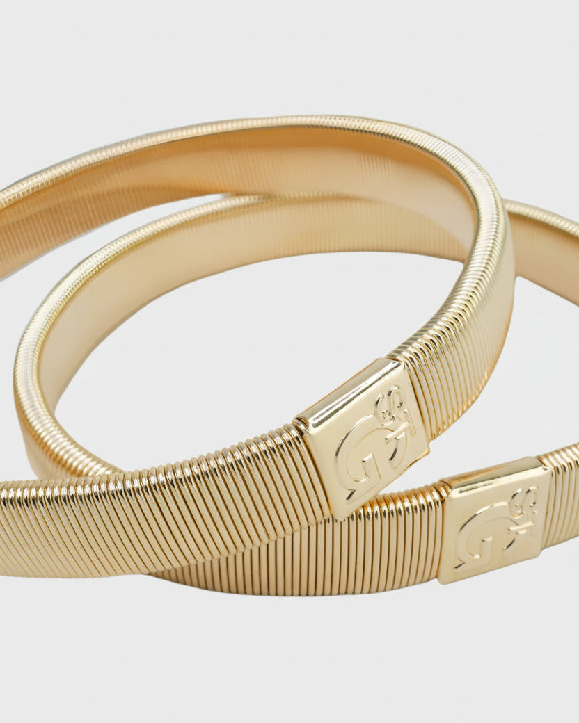 Gilt armbands on a light gray background