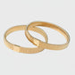Gilt armbands on a light gray background