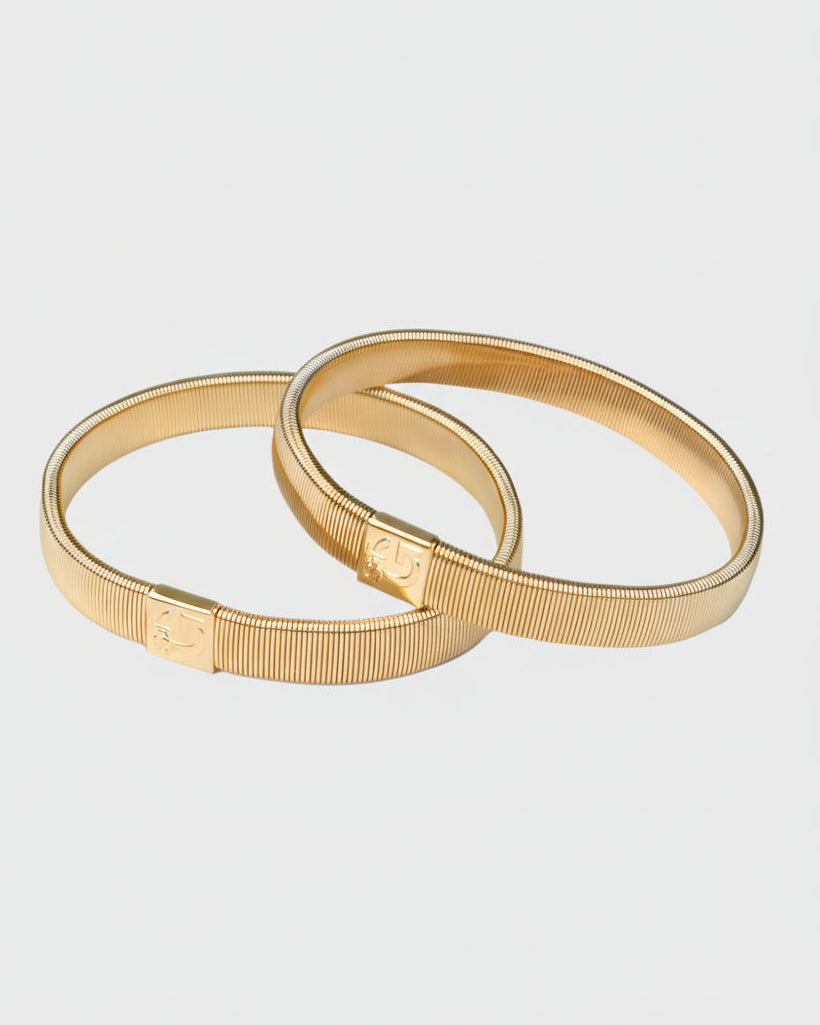 Gilt armbands on a light gray background
