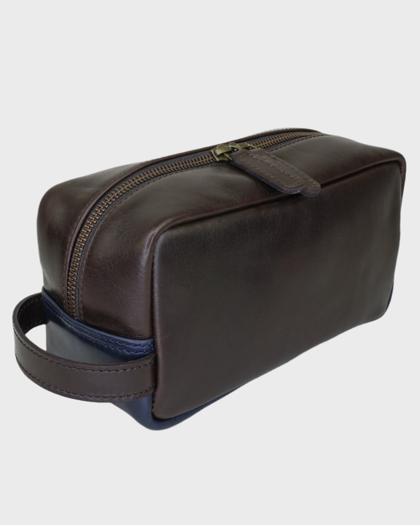 Brown leather toiletry bag with a blue interior on a light gray background