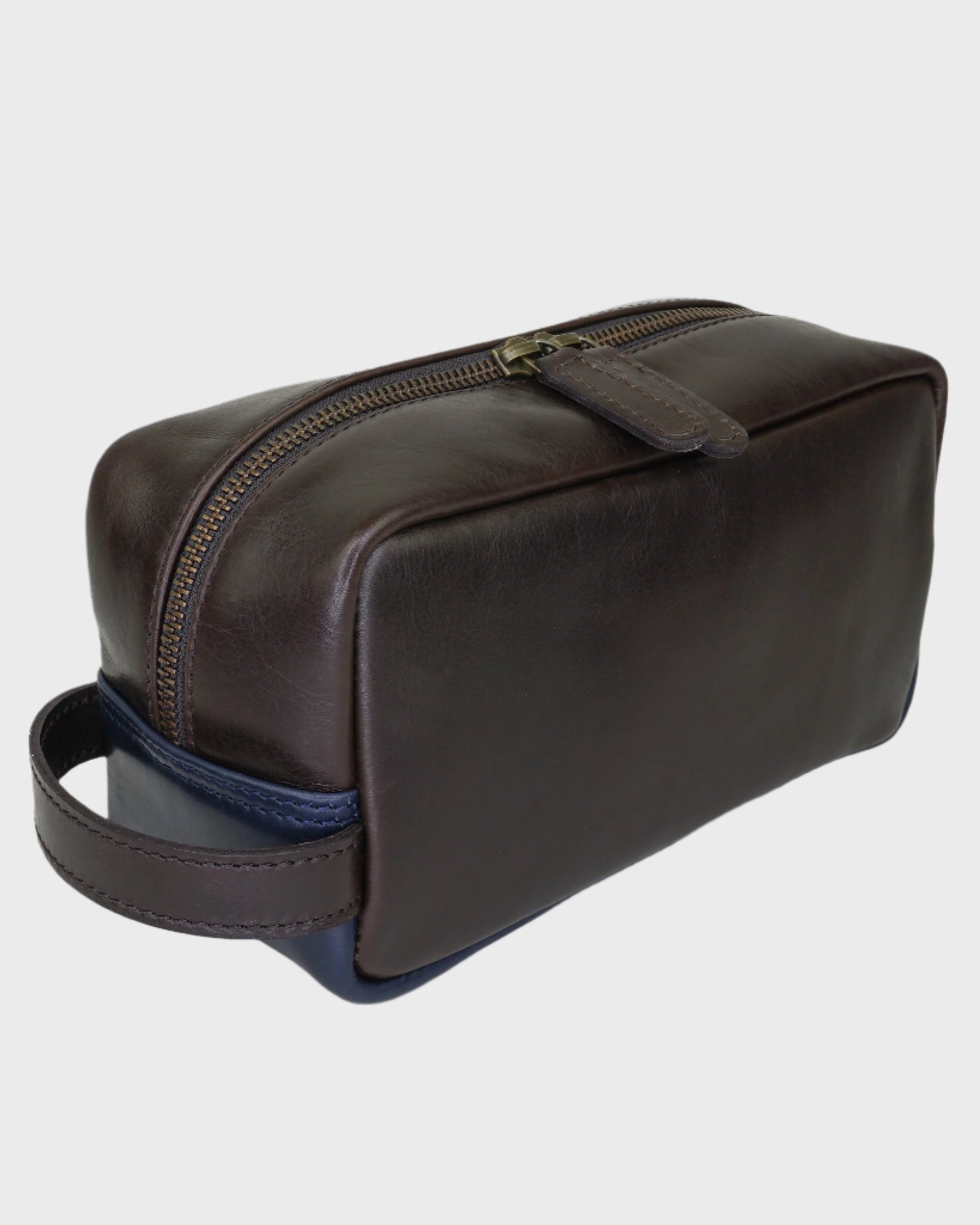 Brown leather toiletry bag with a blue interior on a light gray background