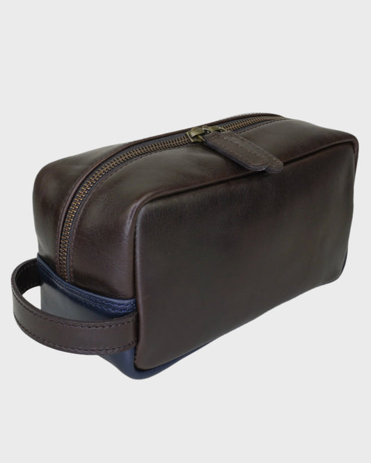 Brown leather toiletry bag with a blue interior on a light gray background