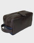 Brown leather toiletry bag with a blue interior on a light gray background