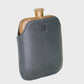 Flask with leather case on a light gray background