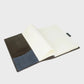 Open notebook with brown and navy cover on a white background