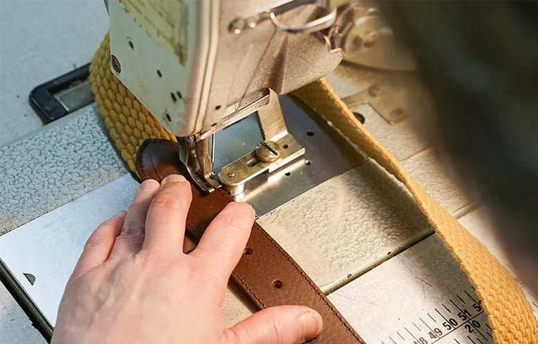 Person using a leather edge trimmer on a belt