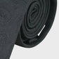 Rolled-up black tie on a white background