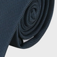 Navy blue tie rolled up on a light gray background