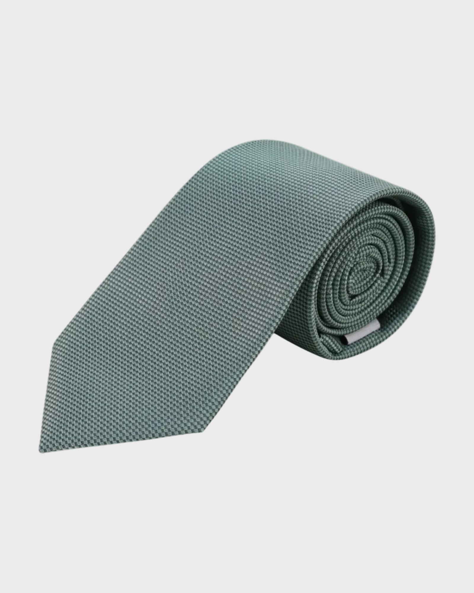 Rolled-up green tie on a light gray background