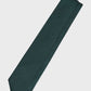Green tie with a brand label on a light gray background