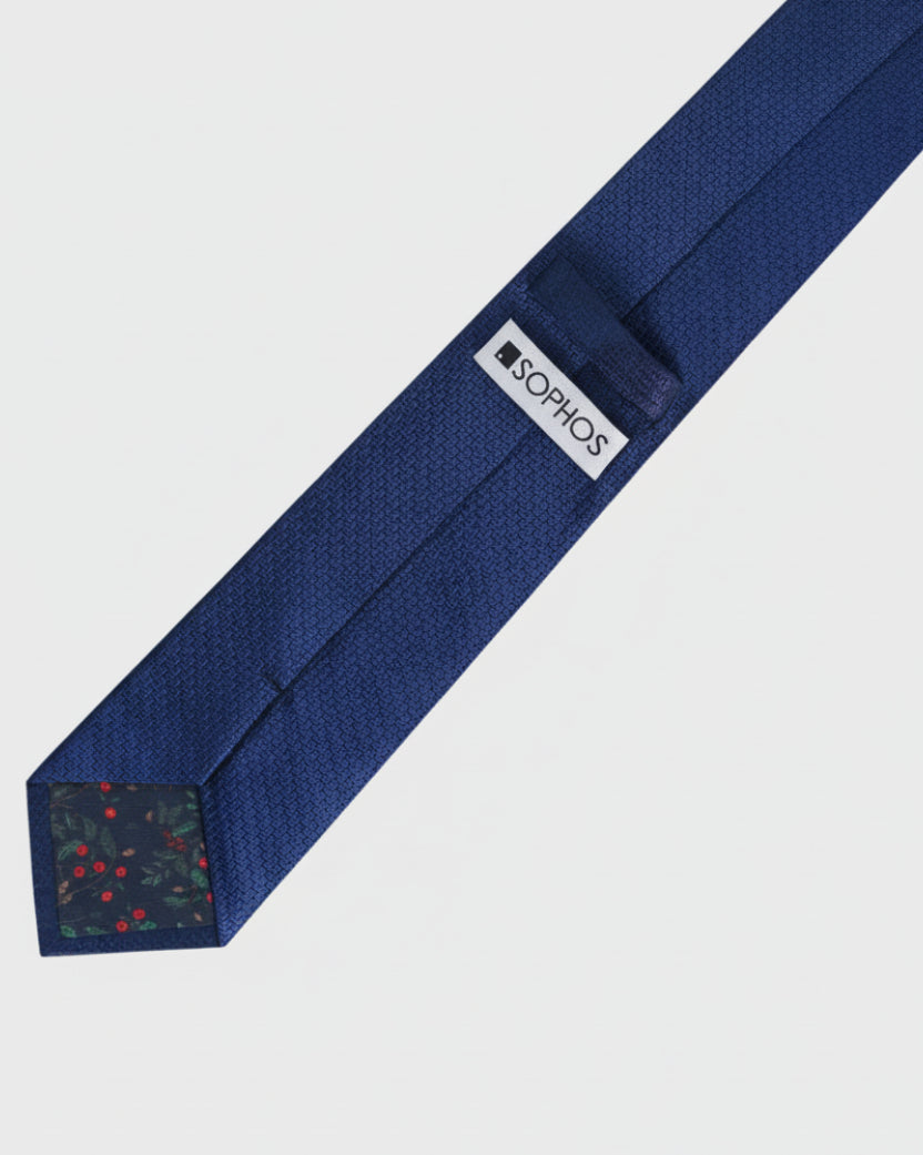 Navy blue tie with a visible brand label on a light gray background