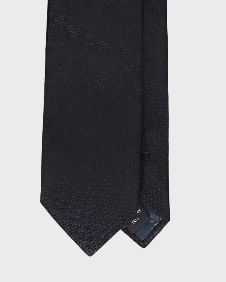 Black textured tie on a light gray background
