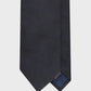 Black tie with a brand label on a light gray background