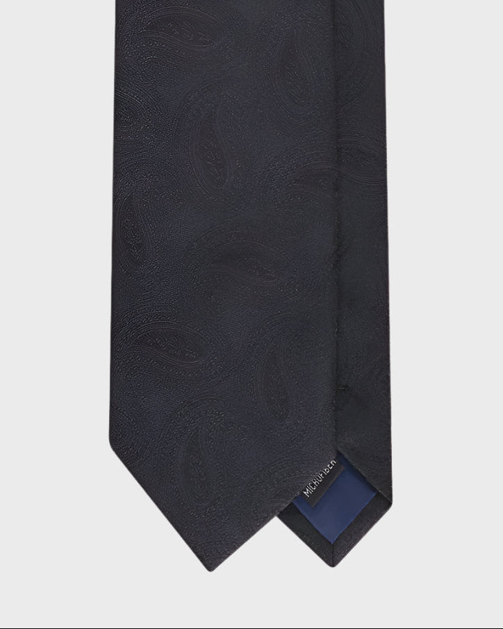 Black tie with a brand label on a light gray background