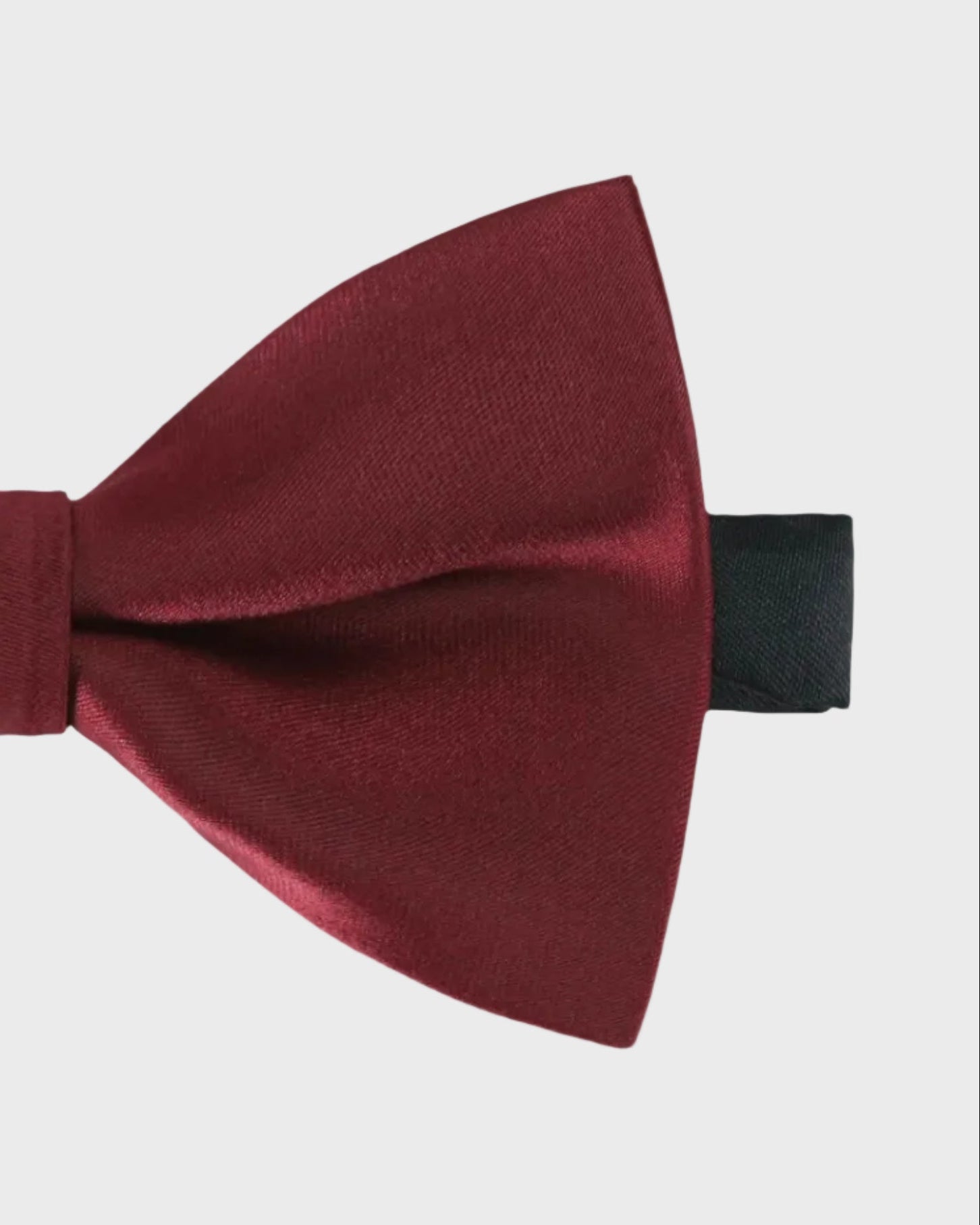 Burgundy bow tie on a light gray background