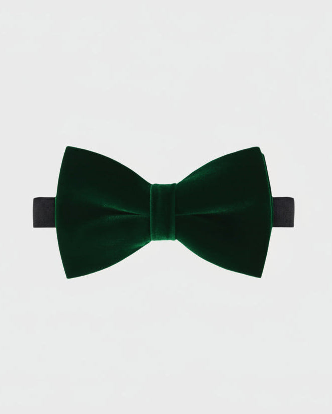 Green velvet bow tie on a light gray background