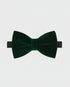 Green velvet bow tie on a light gray background